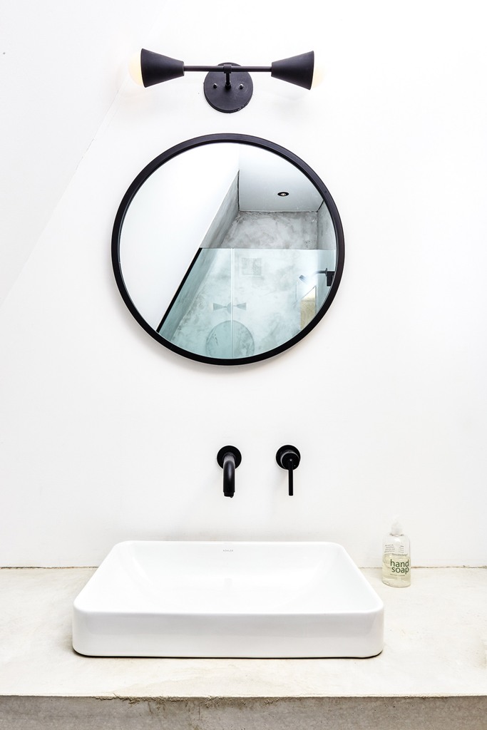 The bathroom is done with concrete and some industrial-like appliances and touches
