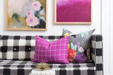 08 a black and white buffalo check sofa is brightened up with a lot of colorful artworks over it