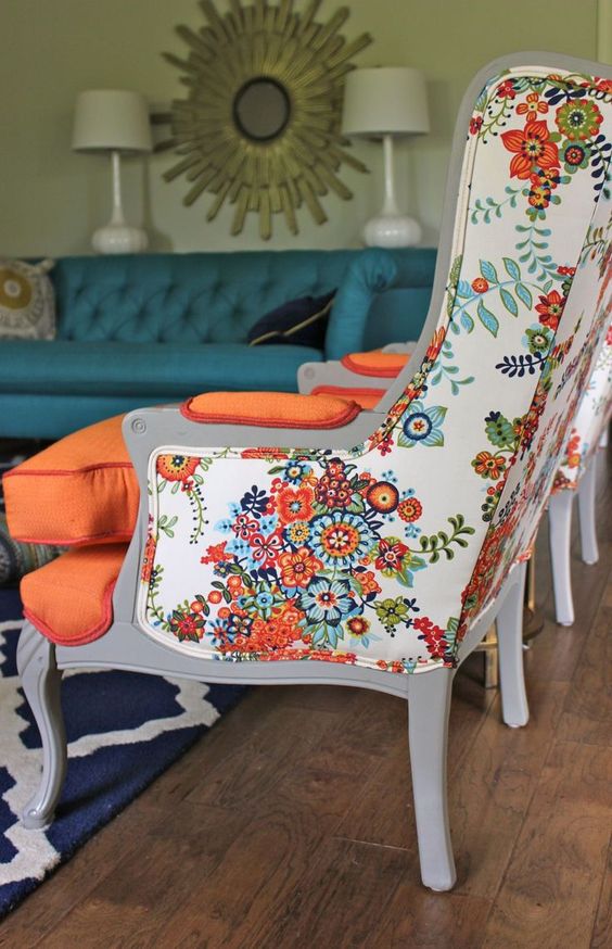 a vintage wingback armchair is given a bold look with floral upholstery on the back and orange on the front