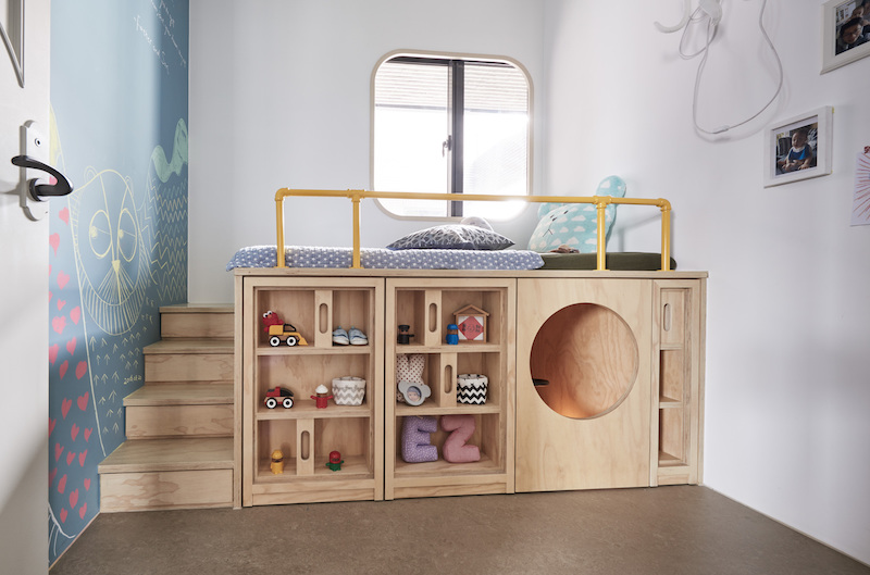The kids' room is done with a large unit comprising storage, a play space and a bed on top