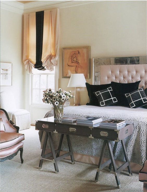 a chic bedroom accomodates not only a large bed but also a vintage chair and a gorgeous trestle desk at the foot of the bed