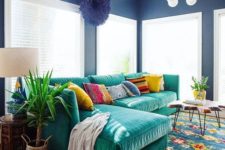 09 an L-shaped emerald velvet sofa with colorful pillows is the main eye-catcher that adds color to the space