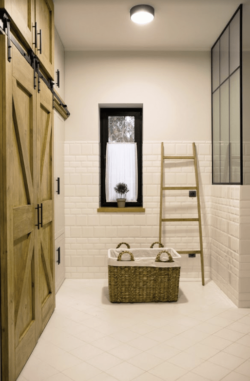 The second bathroom is clad with white tiles, there's a vintage-looking shower with glazing and tiles