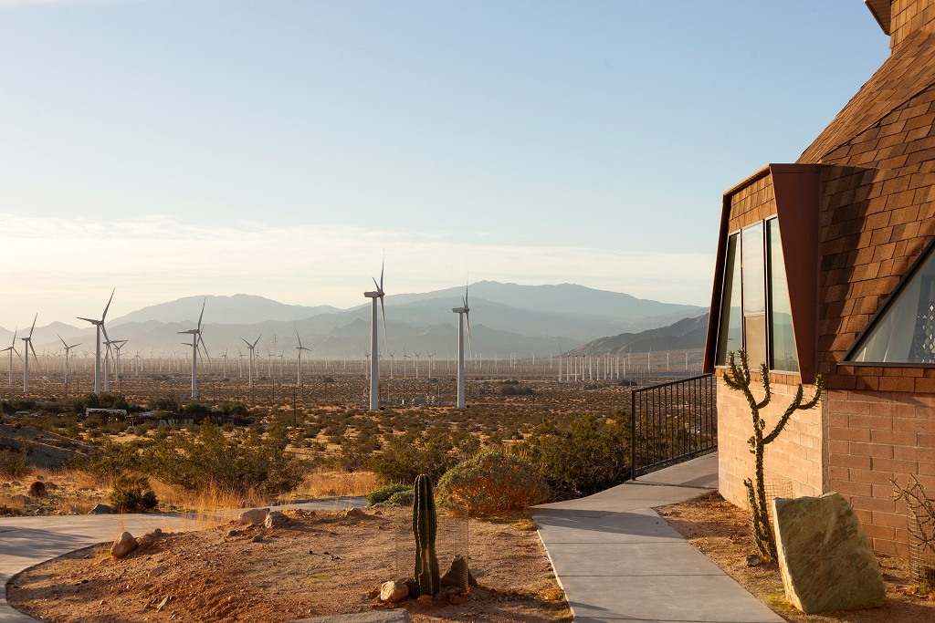 The outdoor spaces feature wind turbines and a typical desert landscape