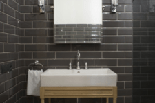 11 The powder room is clad with graphite grey tiles accented with white grout