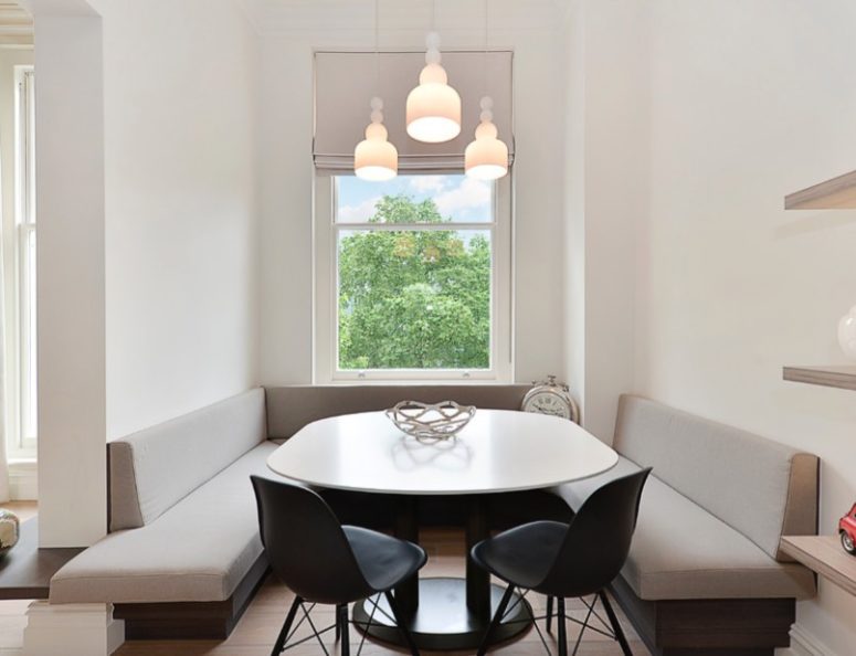 a tiny dining space features built-in banquettes and a rounded table that don't make the space feel small
