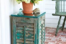 11 an outdoor side table of old shutters and a couple of wooden planks, the aged look fo the shutters is highlighted