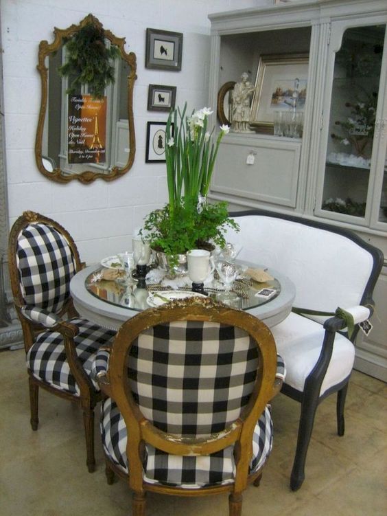 a refined dining space with buffalo check chairs and a black and white bench for a French country feel