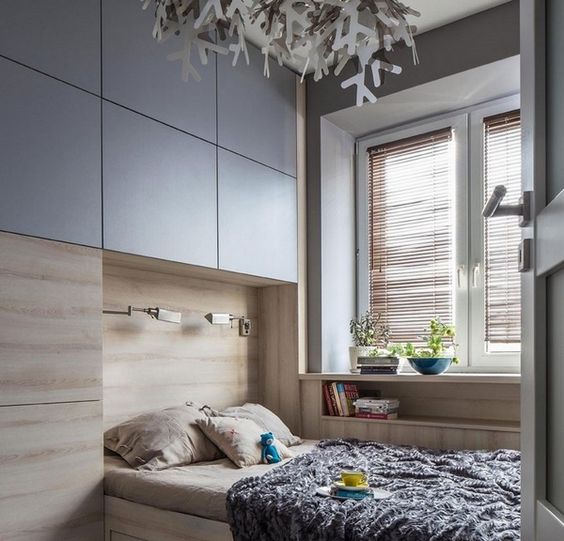 a small bedroom with built-in storage and a built-in bed with increased functionality