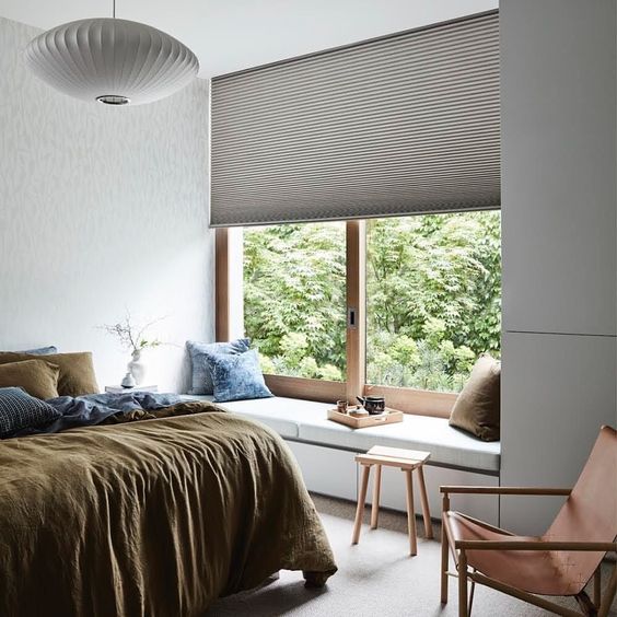 a textural Roman shade adds interest to the bedroom while keeping it private enough