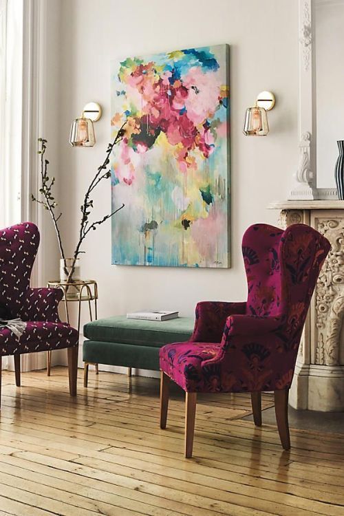 a couple of very bold and colorful upholstered wingback chairs and a bold artwork make the nook vibrant