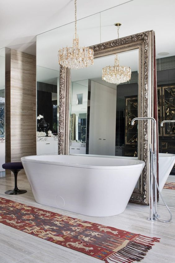 a whole mirror wall with an additional vintage mirror and a gorgeous statement chandelier for a refined feel