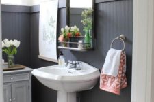 16 black tall wainscoting is a dominating decor feature in this bathroom that makes the space look bold