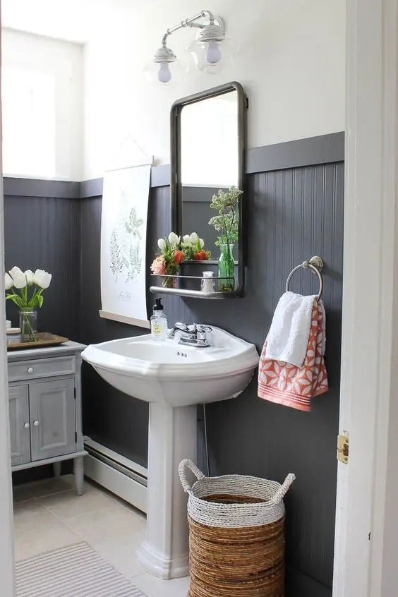 black tall wainscoting is a dominating decor feature in this bathroom that makes the space look bold