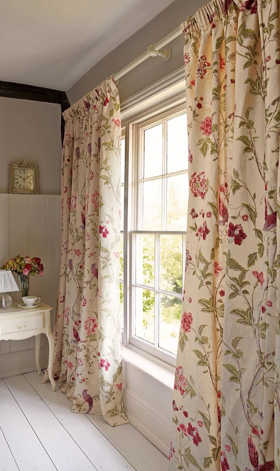 ivory curtains with fuchsia and green floral prints add a refined vintage feel to the space
