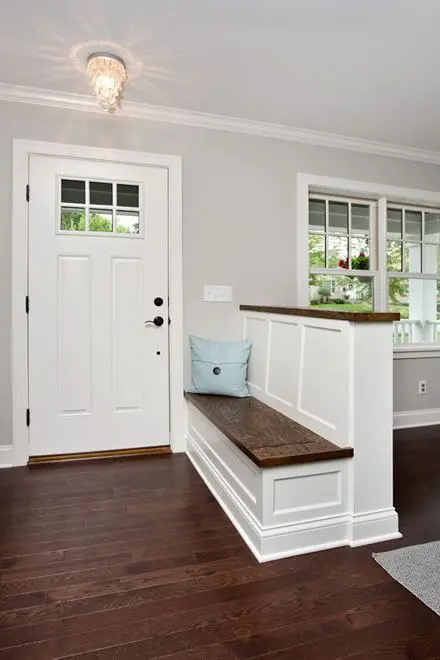 A farmhouse styled pony wall with an entryway bench and a wooden countertop