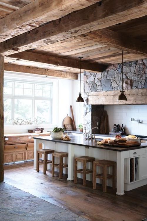 a rustic wooden ceiling with beams, a stone clad fireplace for a super cozy chalet kitchen