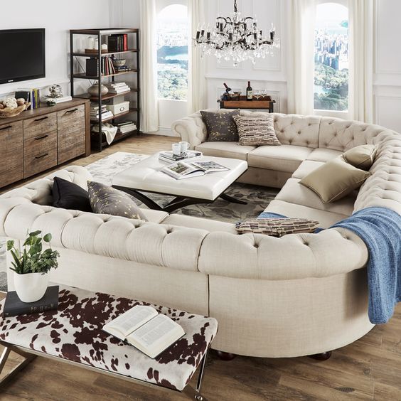 An elegant space with a rustic feel and a gorgeous U shaped tufted sofa of creamy color that makes it more refined