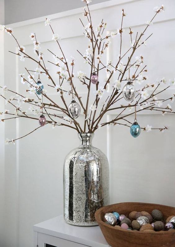 style your console with faux cherry blossom branches and glass egg ornaments plus colorful ones in a wooden bowl