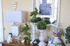 20 a console with moss bunnies and colorful eggs in a jar for a rustic feel