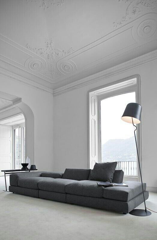a graphite grey long sectional sofa makes a statement in this refined and airy room with much negative space