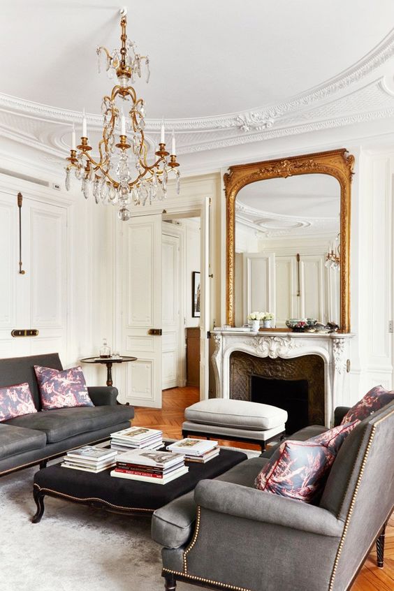 an antique mirror in a gilded frame and a gorgeous chandelier remind of Parisian chic