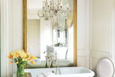 an oversized vintage mirror is a large glam statement in the bath room and makes it bigger