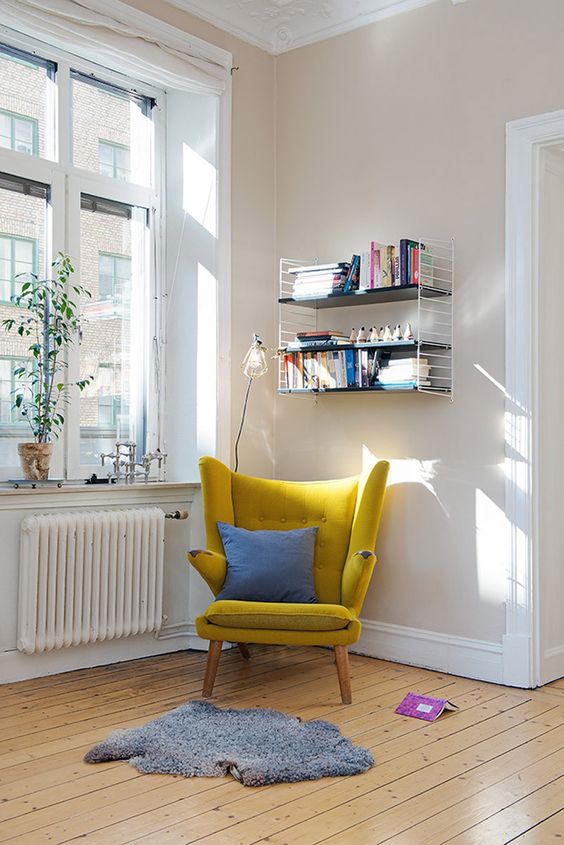 a modern take on a classic wingback in sunny yellow is a great base for a reading space