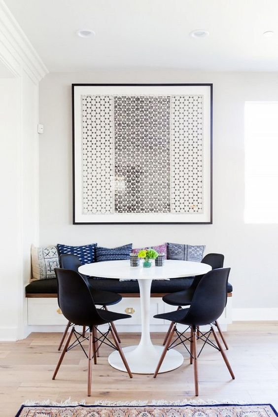 A small mid century modern dining room with a bold graphic artwork that takes over it