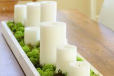 a moss centerpiece with pillar candles in a box is a great idea for any party