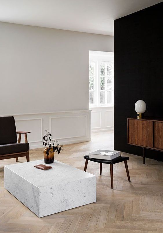 a minimalist living room in black and white and wooden touches lacks only some greenery for a spring feel