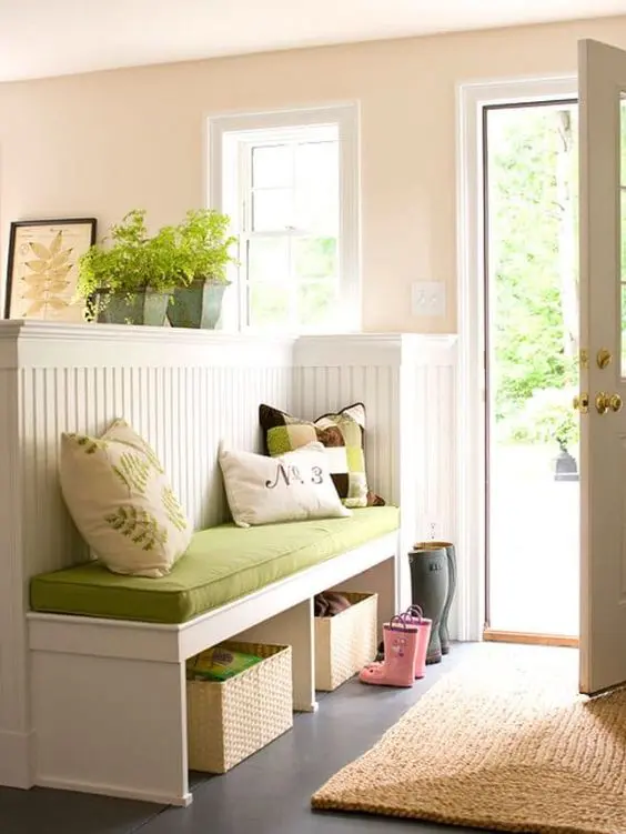 a pony wall with an upholstered bench and functional open storage units for separating the entryway from the rest of the house