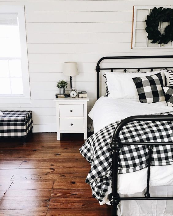 buffalo check pillows, a bedspread and a matching upholstered bench for a cozy farmhouse bedroom