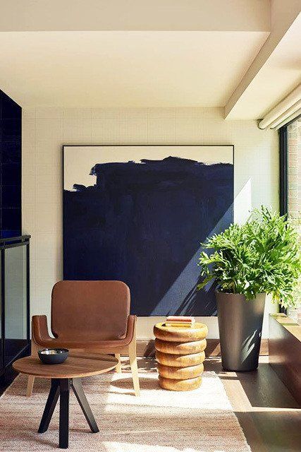 A mid century modern reading nook with a moody artwork that makes it look special