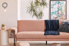 26 a cozy warm-colored living room with a salmon-colored sofa and potted greenery feels like summer