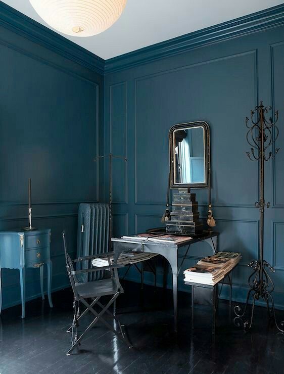 a moody masculine office with a vintage-framed mirror to enliven the space