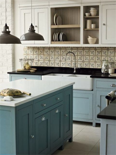 freestanding blue kitchen cabinets with black and white countertops create an elegant feel, and vintage touches add more chic