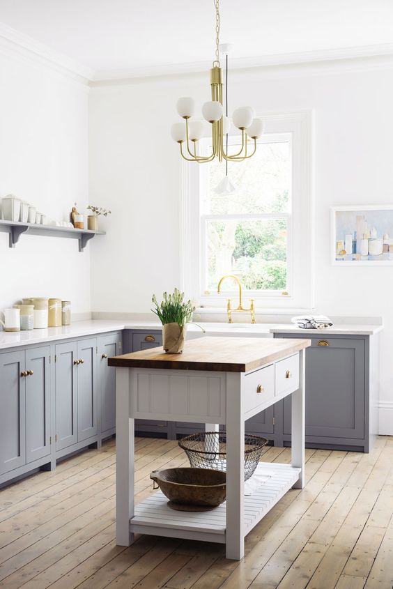 Vintage inspired grey freestanding cabinets with white marble countertops for a peaceful and welcoming kitchen