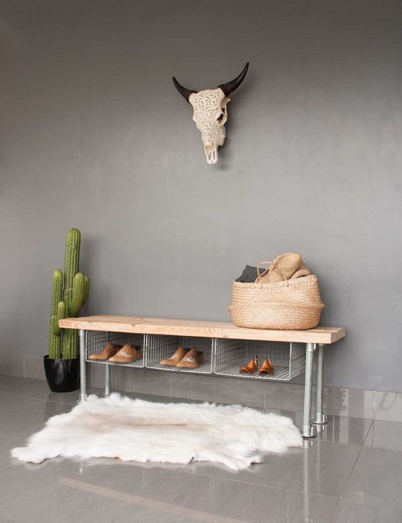 a metal shoe rack bench with wire storage compartments and a wooden top for an industrial space
