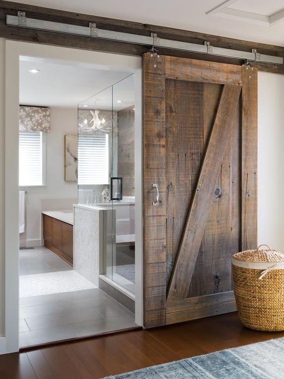 a modern space features sliding barn doors of reclaimed wood that make a bold rustic statement