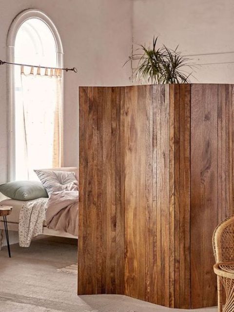 a stained reclaimed wooden screens is a cool idea to separate a studio apartment