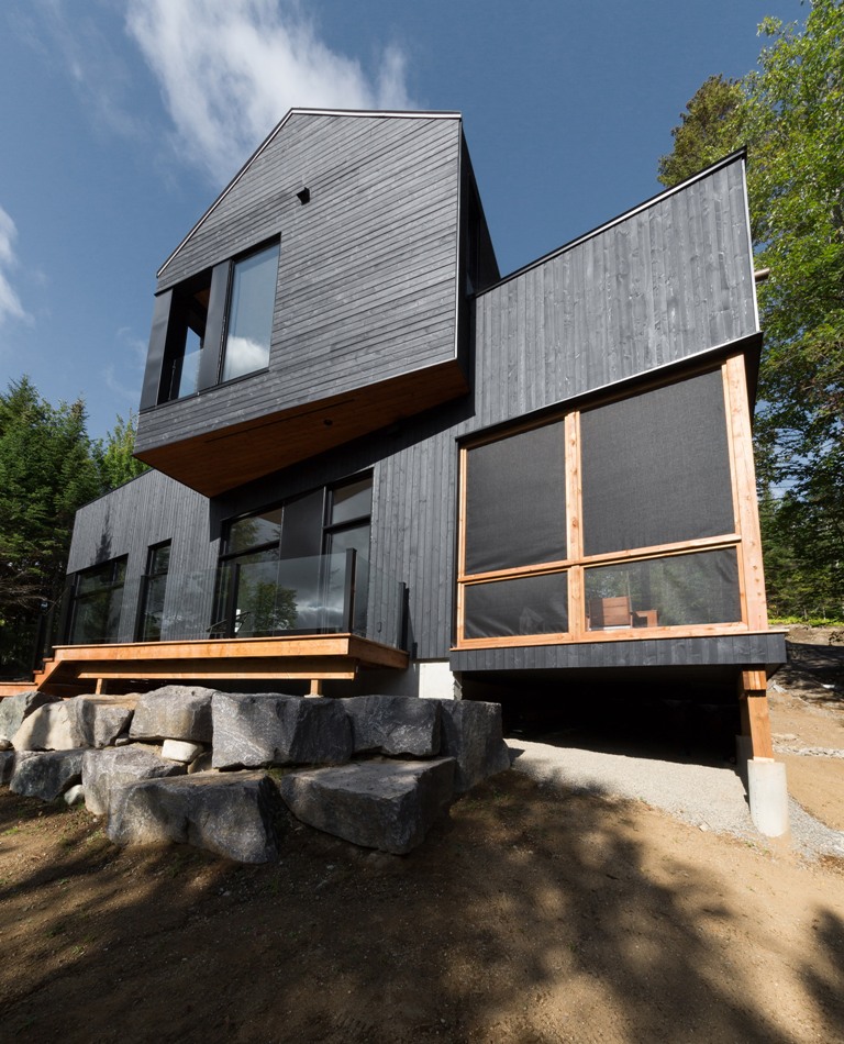 The house features extensive glazings to catch the views of the lake and forests