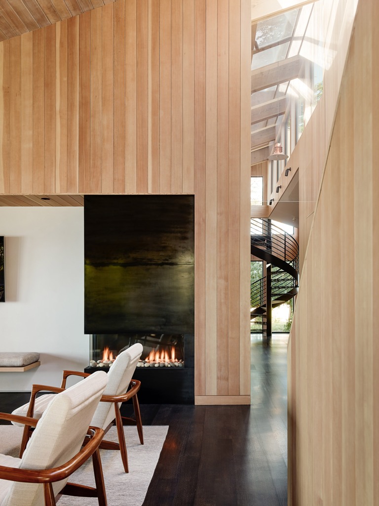 The inside of the home is clad with the same light-colored wood as outside, and the color palette is comfortable and earthy