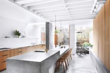 03 a sculptural and long concrete kitchen island features a dining space on one end