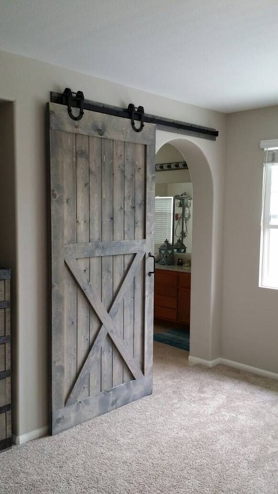 a sliding barn door on black metal adds coziness and warmth that only a barn piece can bring
