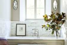 03 a vintage space with a bathtub clad with marble and the walls around it clad with the same for a refined feel