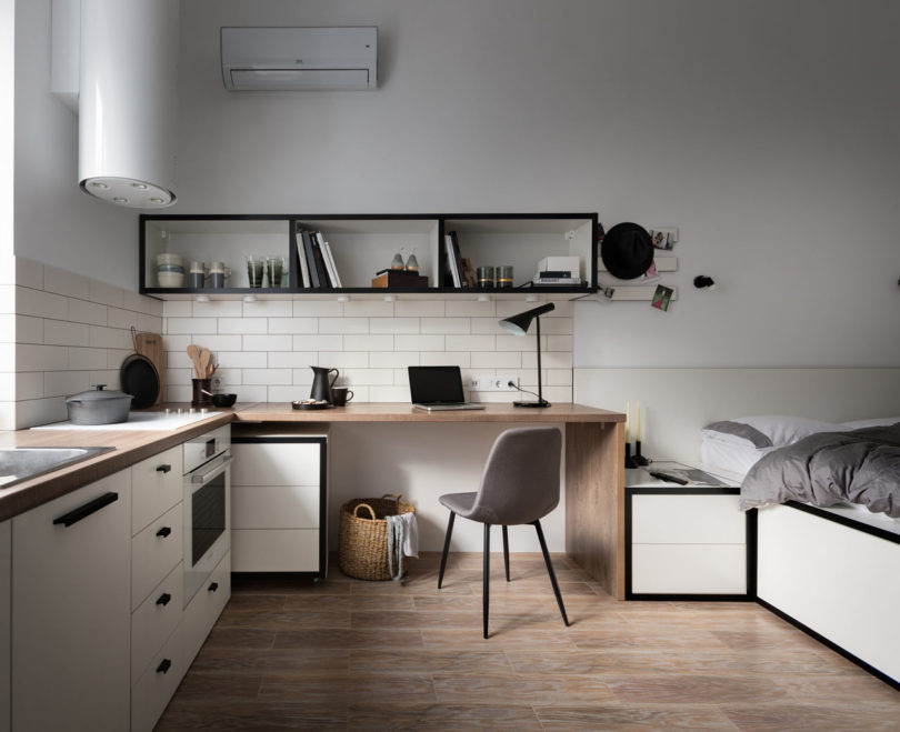 The furniture is modern and simple, there's a built in cooker, a modern hood with lights and much storage