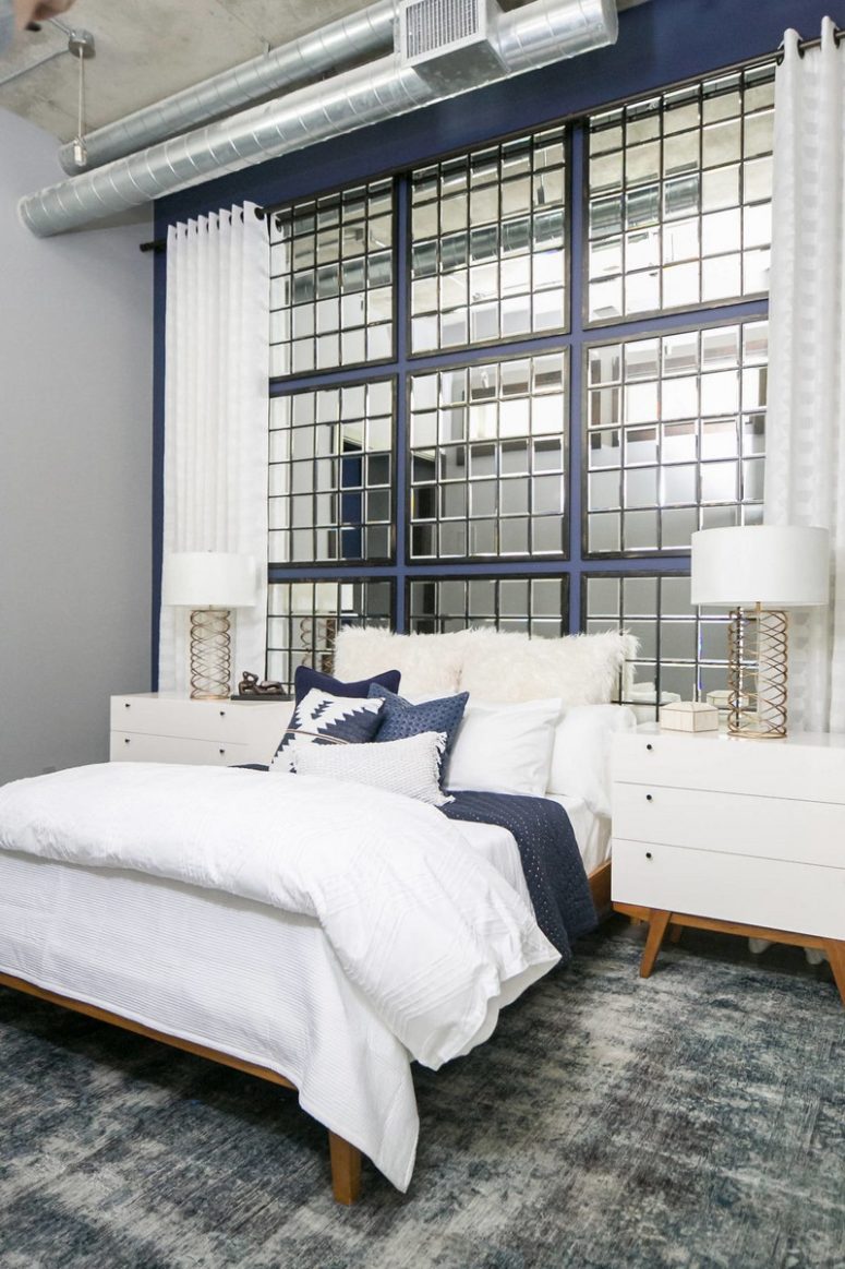 The guest bedroom is more glam, with exposed pipes, a concrete ceiling and a framed mirror headboard wall