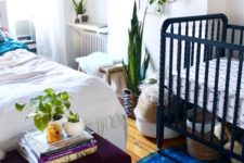 04 a boho shared master bedroom with a nursery nook with a navy crib and baskets for storage