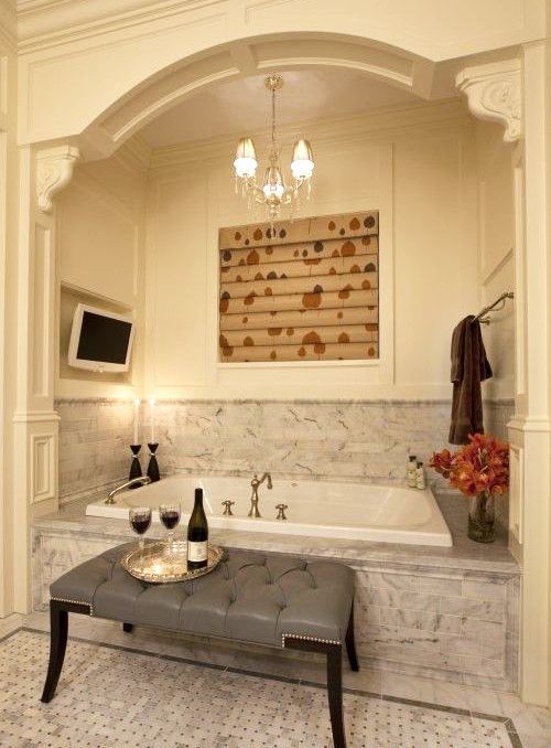 a chic and romantic niche with a bathtub clad with grey marble tiles and a backsplash covered with them, too